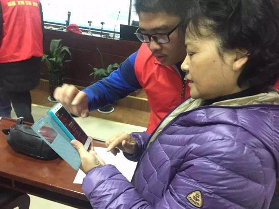 社区志愿者教老年人用智能手机 (图文无关）